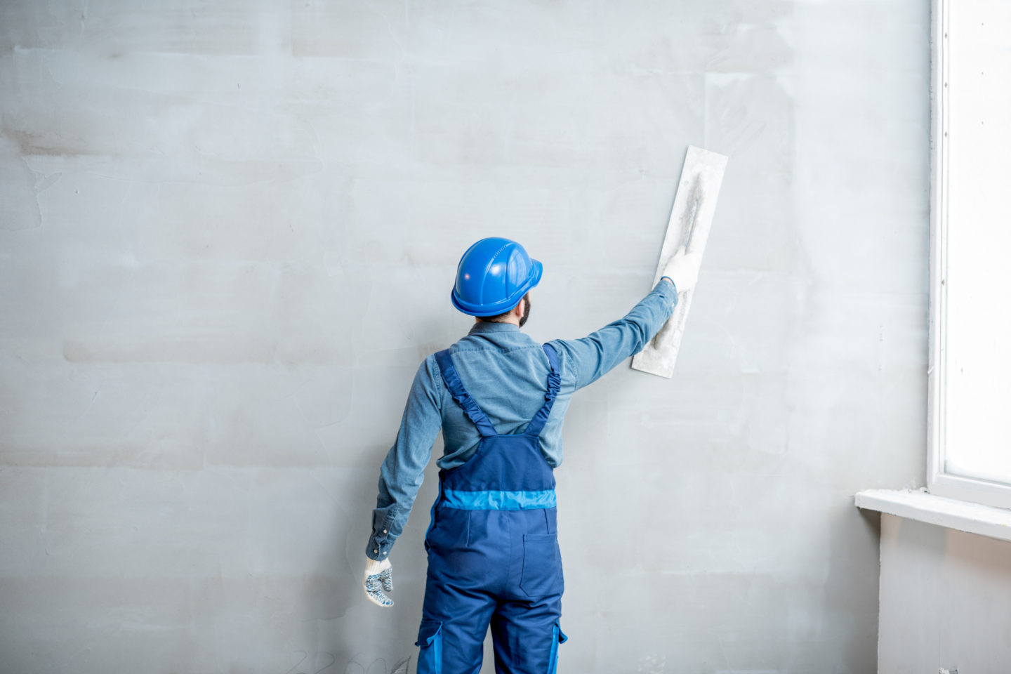 man plastering an interior wall